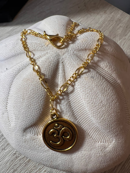 Gold-tone Ohm or Lotus 7.5 bracelet