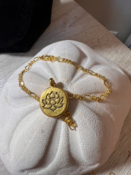 Gold-tone Ohm or Lotus 7.5 bracelet